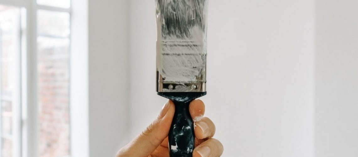 person holding white paint brush